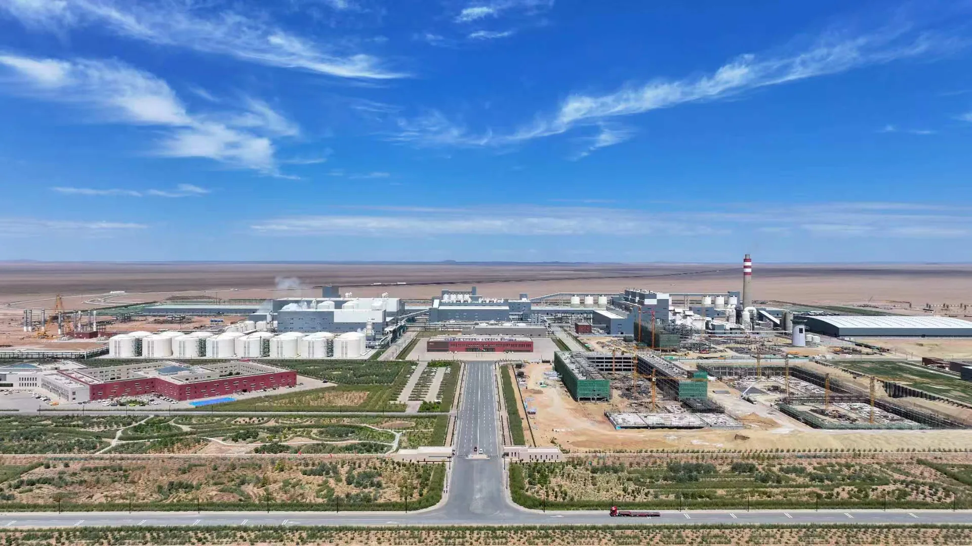 Approach road through desert landscaping toward the Alxa Yingen producing plant, tank farm and stack ahead, which supplies the soda ash and sodium bicarbonate we export