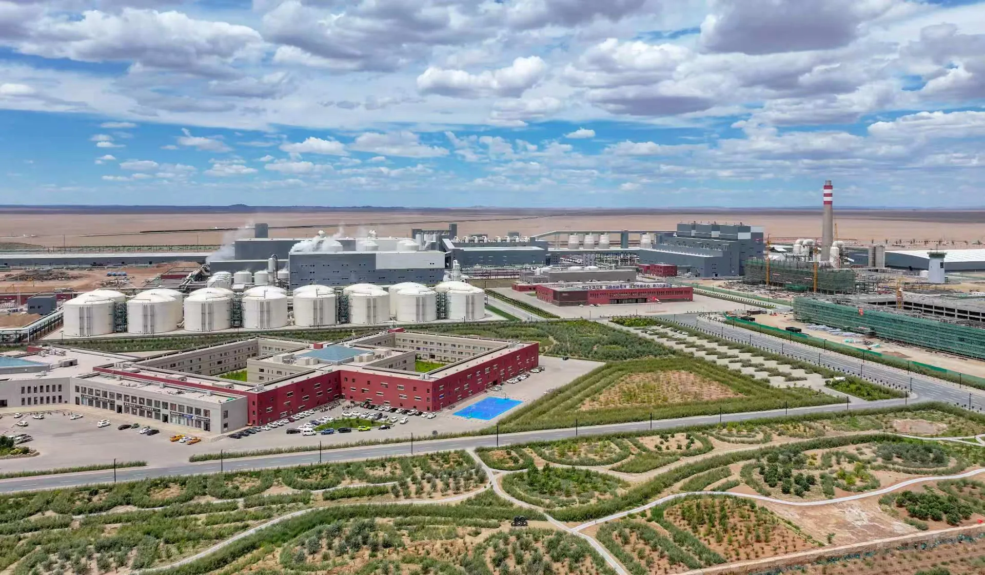 Bulk storage tank farm at the Alxa Yingen producing plant, plant offices and process buildings behind, before soda ash and sodium bicarbonate are packed for export